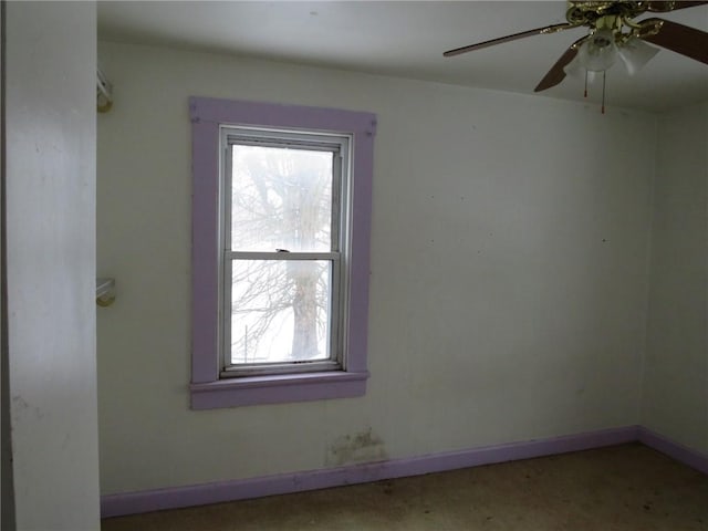 spare room featuring a ceiling fan and baseboards