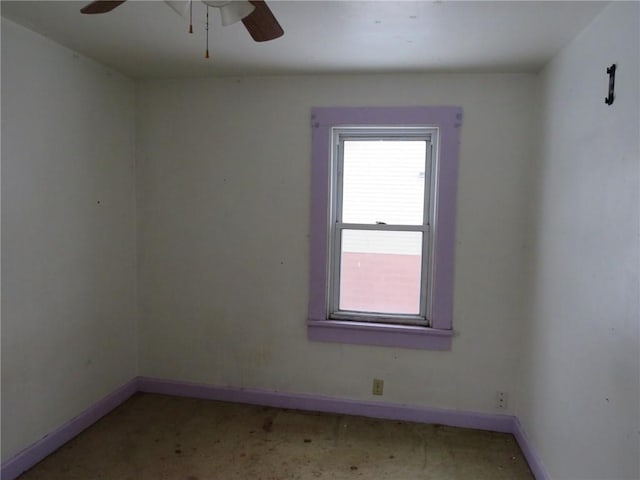 spare room with ceiling fan and baseboards