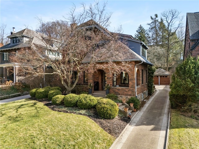 view of front of property featuring brick siding, a front yard, and a shingled roof