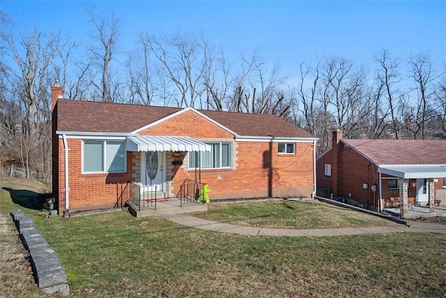 bungalow-style house with a front yard, brick siding, a chimney, and roof with shingles