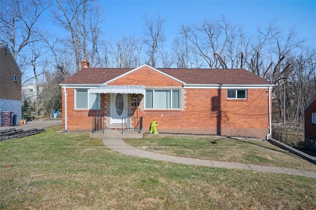 bungalow with roof with shingles, brick siding, a chimney, and a front yard