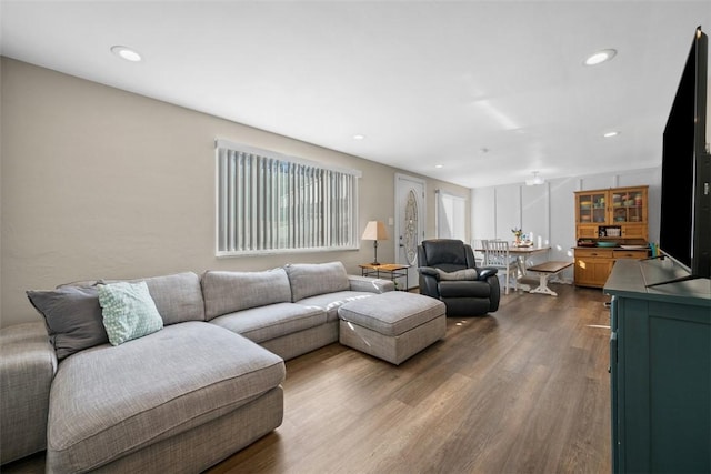 living room with dark wood-style floors and recessed lighting