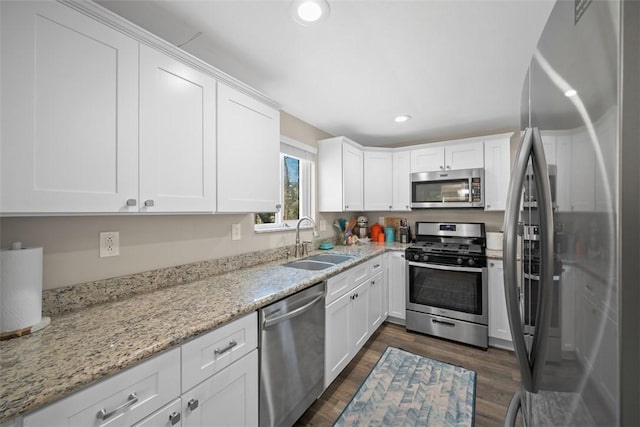 kitchen featuring white cabinetry, dark wood-style flooring, stainless steel appliances, and a sink