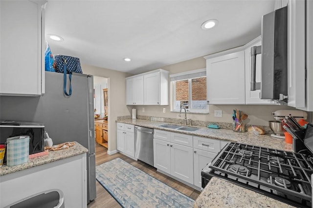 kitchen featuring black range with gas cooktop, a sink, light wood-style floors, white cabinets, and dishwasher