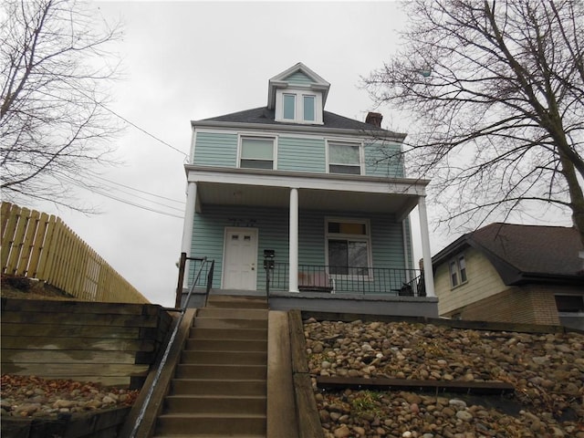 traditional style home with stairway, fence, and a porch