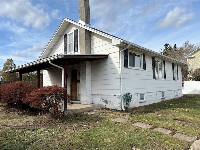 view of front of house with a front yard, fence, and a chimney