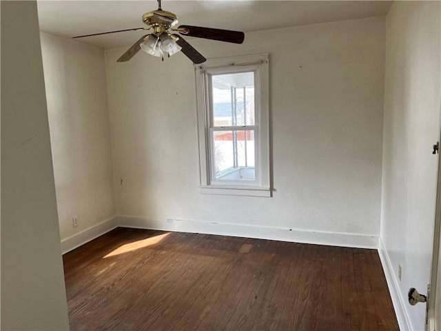 empty room with dark wood-style floors, baseboards, and a ceiling fan