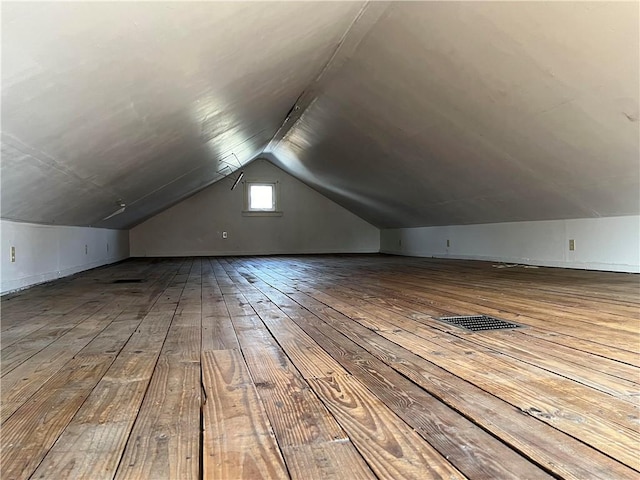 bonus room featuring vaulted ceiling, hardwood / wood-style floors, and visible vents