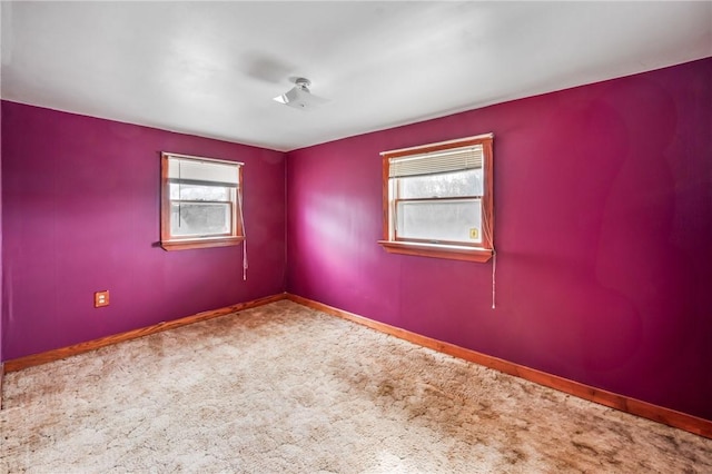 unfurnished room featuring carpet floors and baseboards