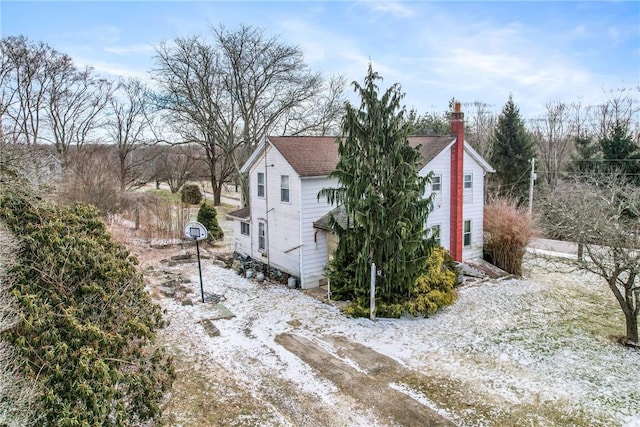 view of home's exterior featuring a shingled roof and a chimney