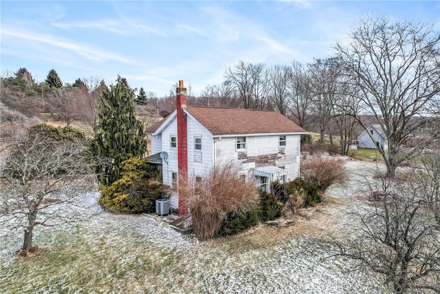 view of property exterior featuring central air condition unit and a chimney