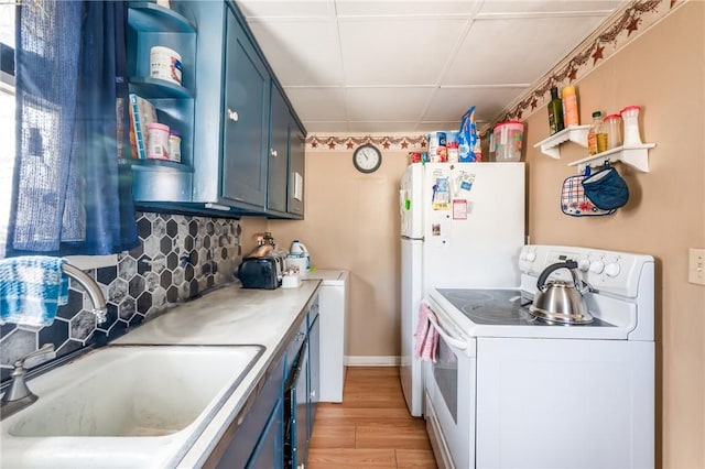 kitchen with blue cabinets, white appliances, a sink, and open shelves