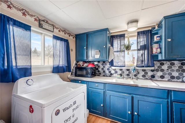 kitchen with blue cabinetry and washer / clothes dryer