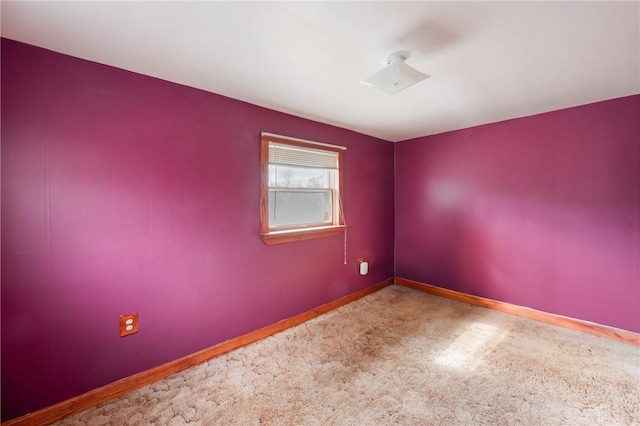 carpeted spare room with baseboards