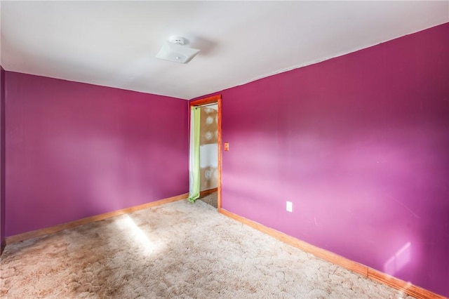 empty room featuring carpet floors and baseboards