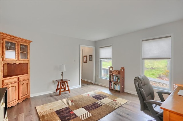 office space featuring baseboards and light wood finished floors