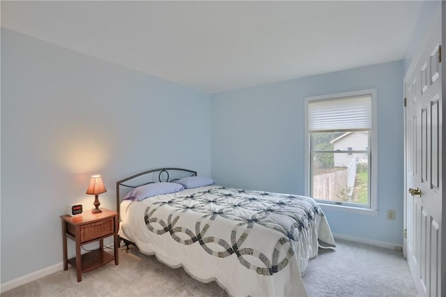 bedroom with light carpet and baseboards