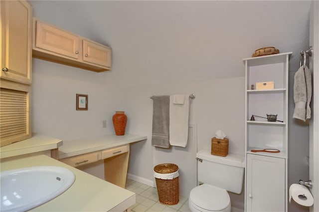 bathroom with toilet, baseboards, and a sink