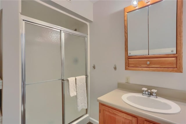 bathroom with a shower stall and vanity