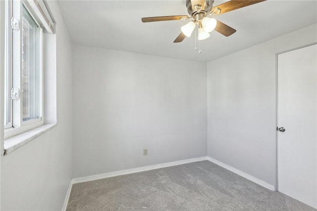 empty room with carpet, baseboards, and a ceiling fan