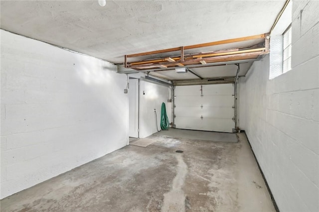 garage with concrete block wall and a garage door opener