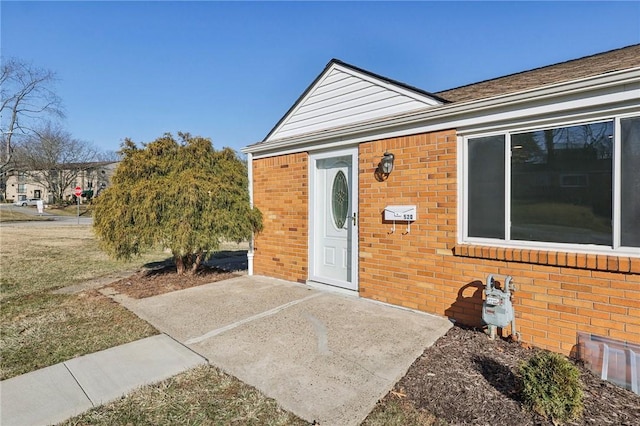 view of exterior entry featuring brick siding