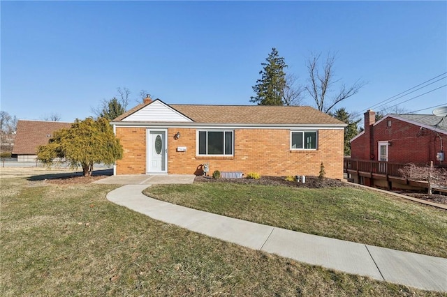 ranch-style home featuring a front yard and brick siding