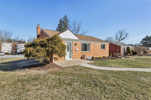 single story home with a front lawn, a chimney, and brick siding