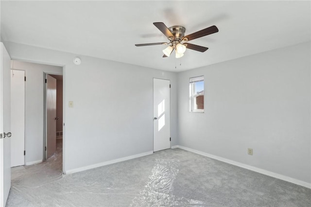 unfurnished room with ceiling fan and baseboards