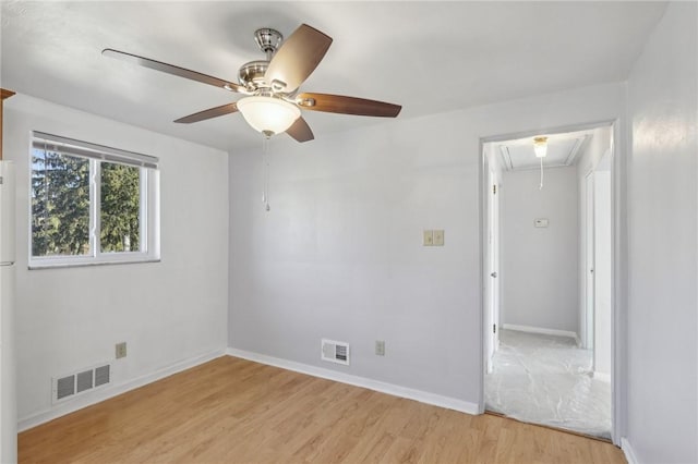 unfurnished bedroom featuring visible vents, light wood-style flooring, attic access, and baseboards