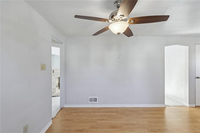 spare room with light wood-style floors, visible vents, ceiling fan, and baseboards