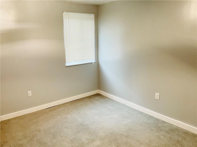 empty room featuring carpet and baseboards