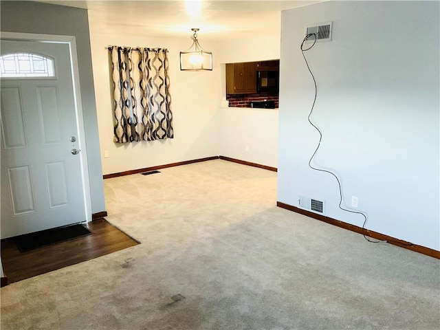 carpeted foyer entrance featuring baseboards and visible vents