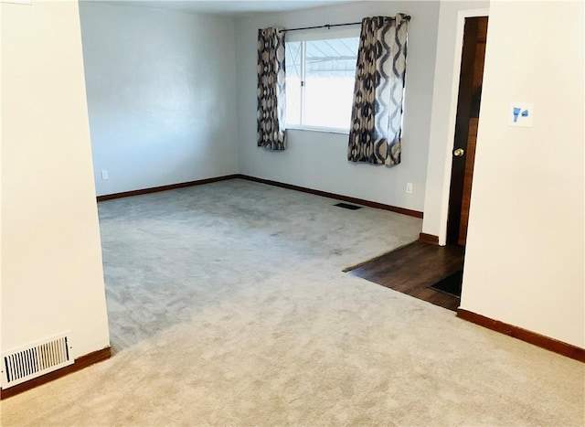 carpeted empty room with visible vents and baseboards