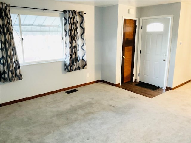 carpeted empty room featuring visible vents and baseboards