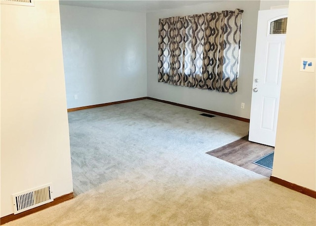 carpeted empty room with baseboards and visible vents