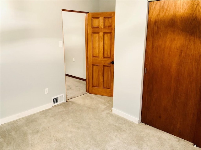 carpeted spare room with baseboards and visible vents