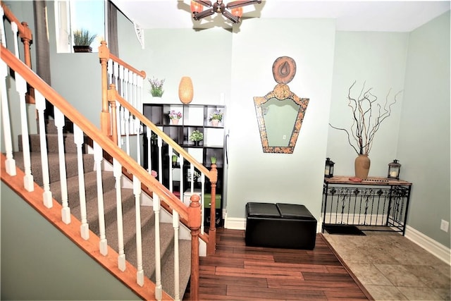 staircase with a notable chandelier, baseboards, and wood finished floors