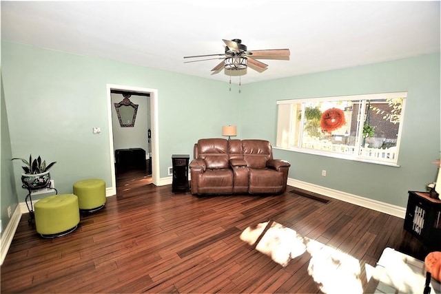 living area with a ceiling fan, baseboards, visible vents, and wood finished floors