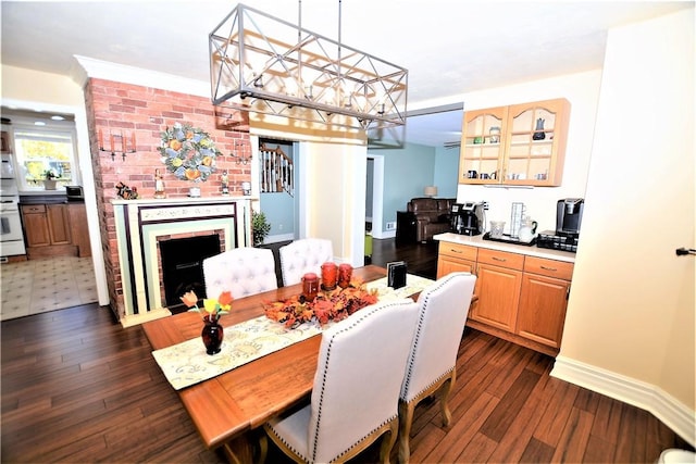 dining space featuring a brick fireplace, dark wood finished floors, and baseboards