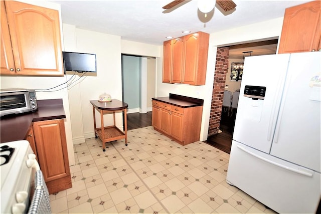 kitchen featuring range, a ceiling fan, dark countertops, light floors, and white fridge with ice dispenser