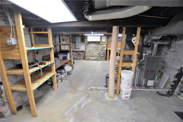 unfinished below grade area featuring electric panel and heating unit