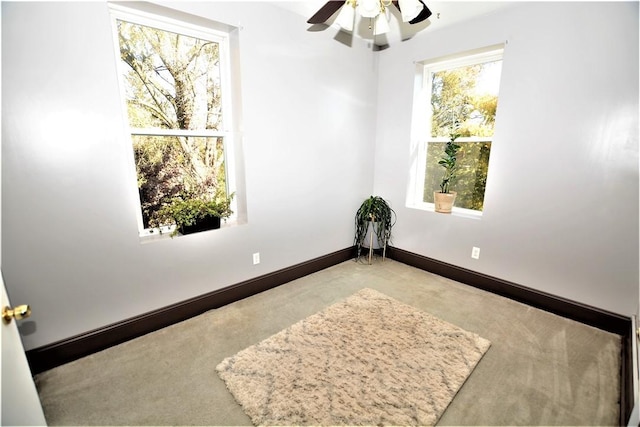 empty room with ceiling fan and baseboards