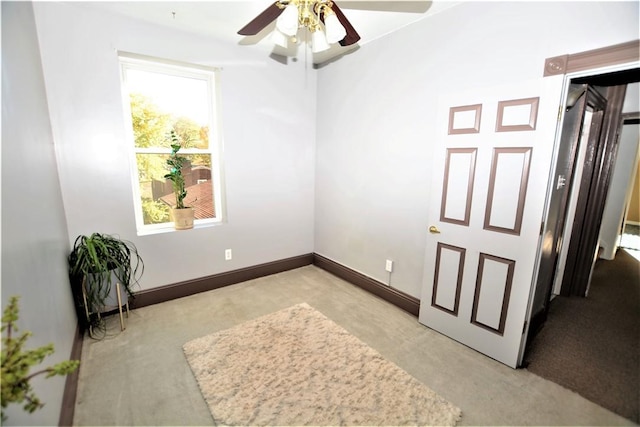 unfurnished room featuring light carpet, baseboards, and a ceiling fan
