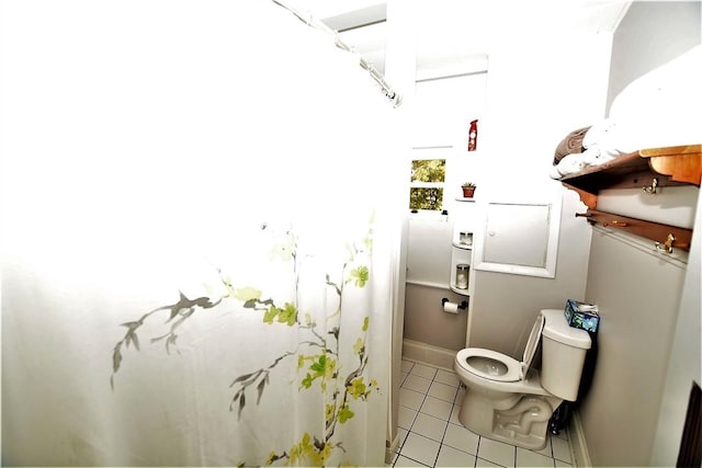 bathroom featuring toilet, baseboards, and tile patterned floors