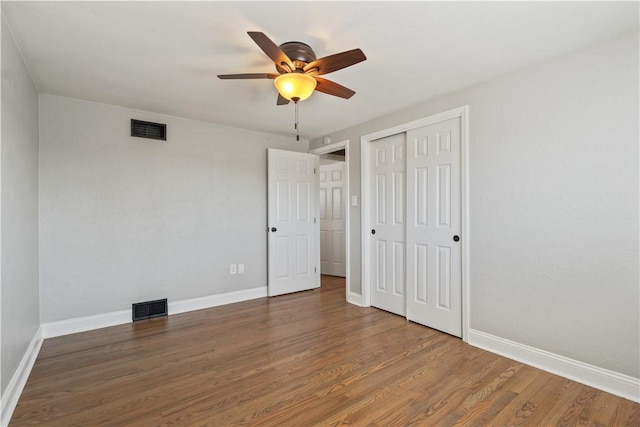 unfurnished bedroom featuring baseboards, visible vents, and wood finished floors