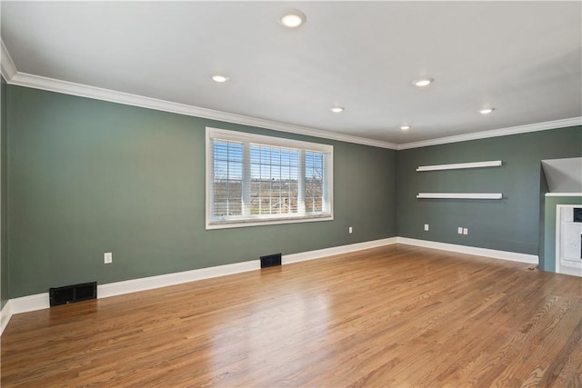 unfurnished room with visible vents, crown molding, and wood finished floors