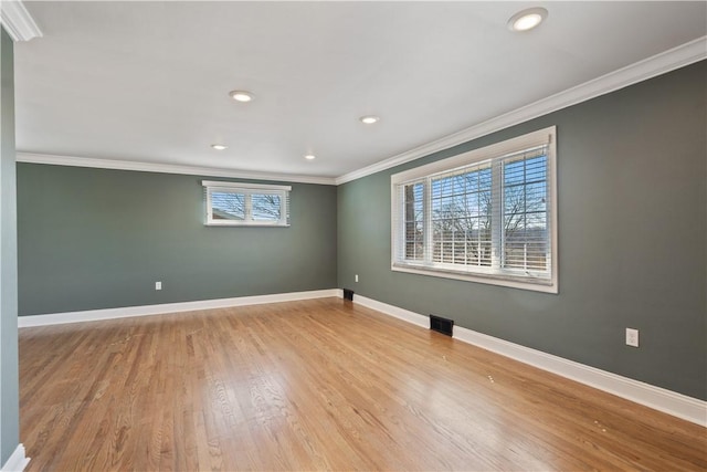 empty room with visible vents, baseboards, ornamental molding, wood finished floors, and recessed lighting