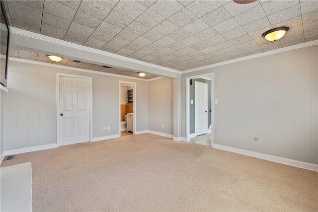 carpeted spare room featuring baseboards, visible vents, and ornamental molding