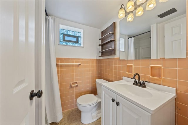 bathroom with tile walls, toilet, and vanity